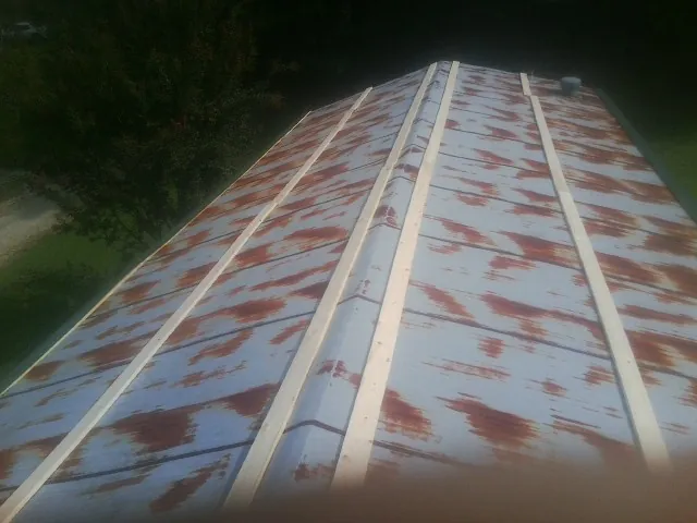 Rusted metal roof panels with new wood purlins before replacement — Storm Damage Roof Repair in Danvers by Roofing Brothers